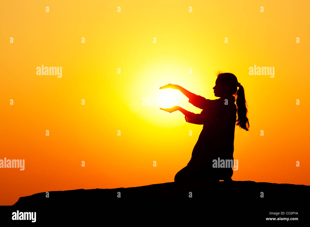 Indische Mädchen halten die Sonne. Silhouette. Indien Stockfoto
