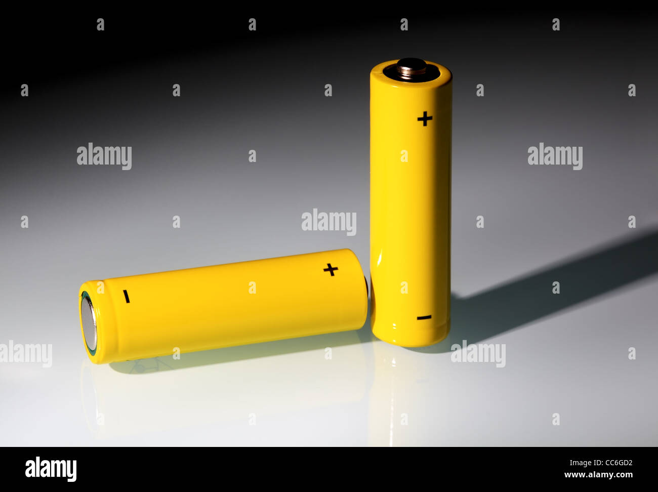 Zwei gelbe AA Batterien in einem Lichtstrahl. Ökologie-Energie-Konzept. Stockfoto