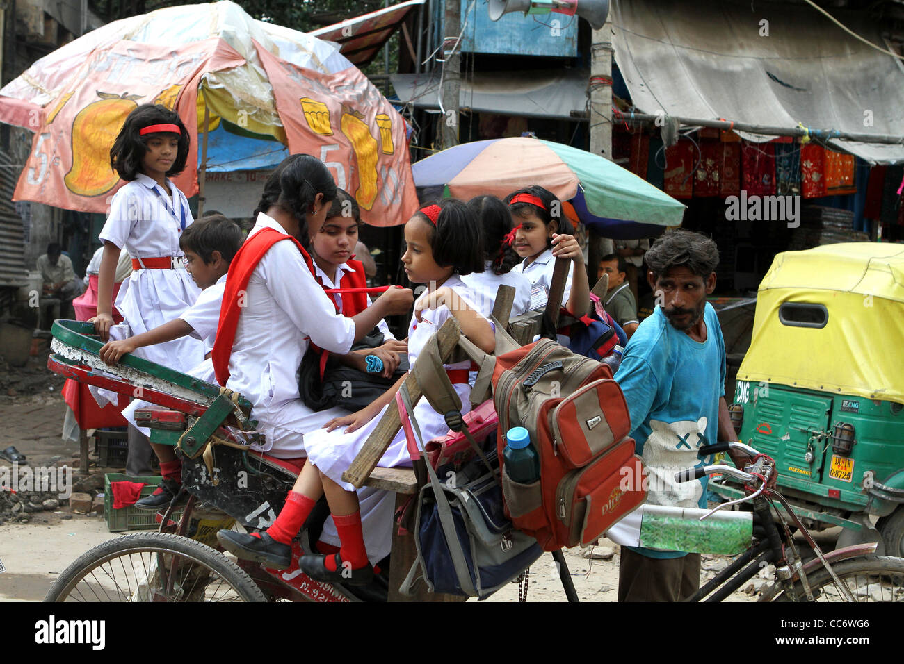 Indische Schülerinnen und Schüler auf dem Weg zur Schule in einem Pedal Rikscha. Delhi. Indien Stockfoto