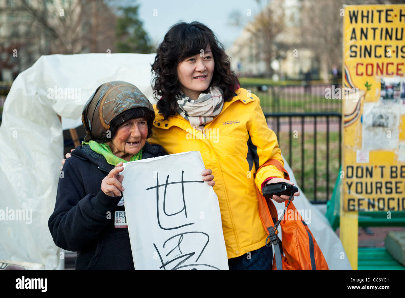 Washington DC, ein japanischer Tourist mit Connie Picciotto, ein Demonstrant, der seit 1981 vor dem weißen Haus. Stockfoto