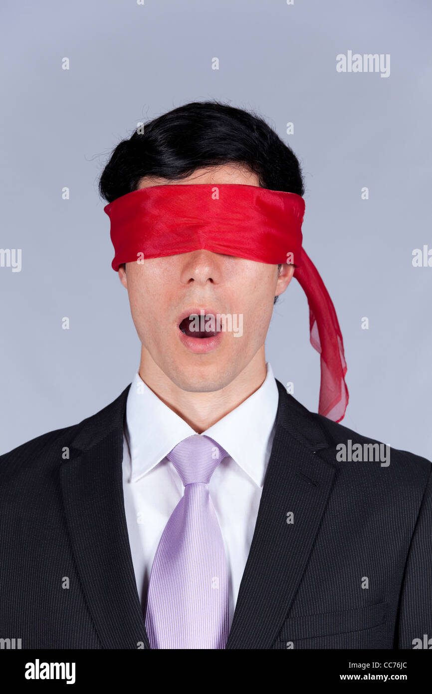 Geisel Geschäftsmann mit einem roten Augenbinde für seine Augen (isoliert auf grau) Stockfoto