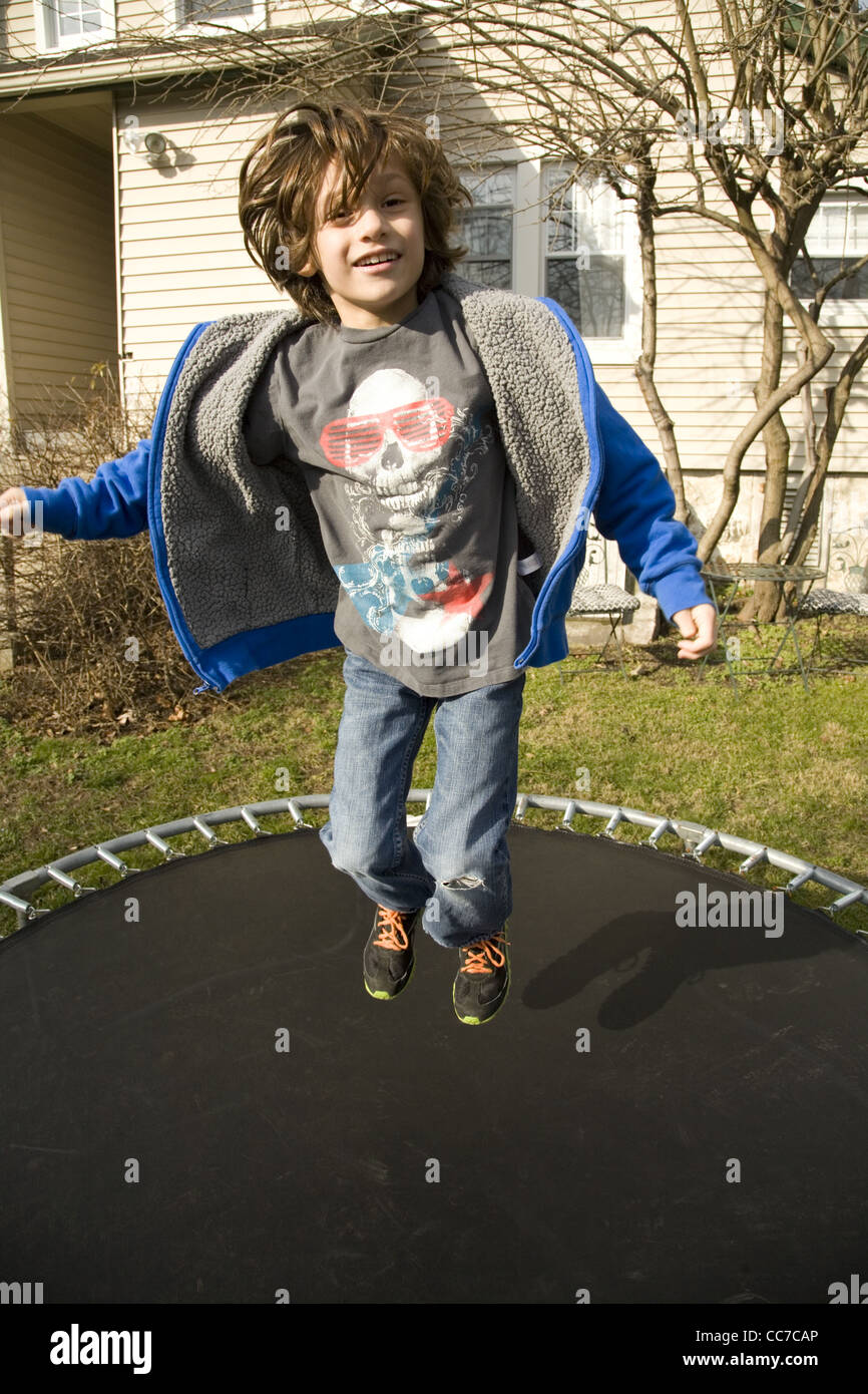 Sieben Jahre alter Junge hat Spaß trainieren auf einem Trampolin in seinem Hinterhof in Darien, Connecticut. Stockfoto