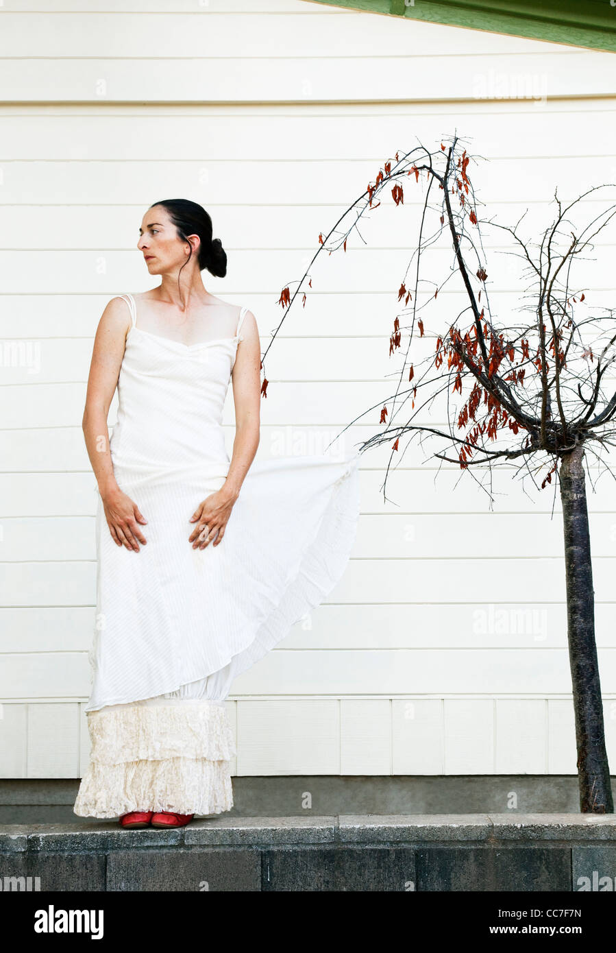 Kaukasische Frau mit Brautkleid auf Baum gefangen Stockfoto