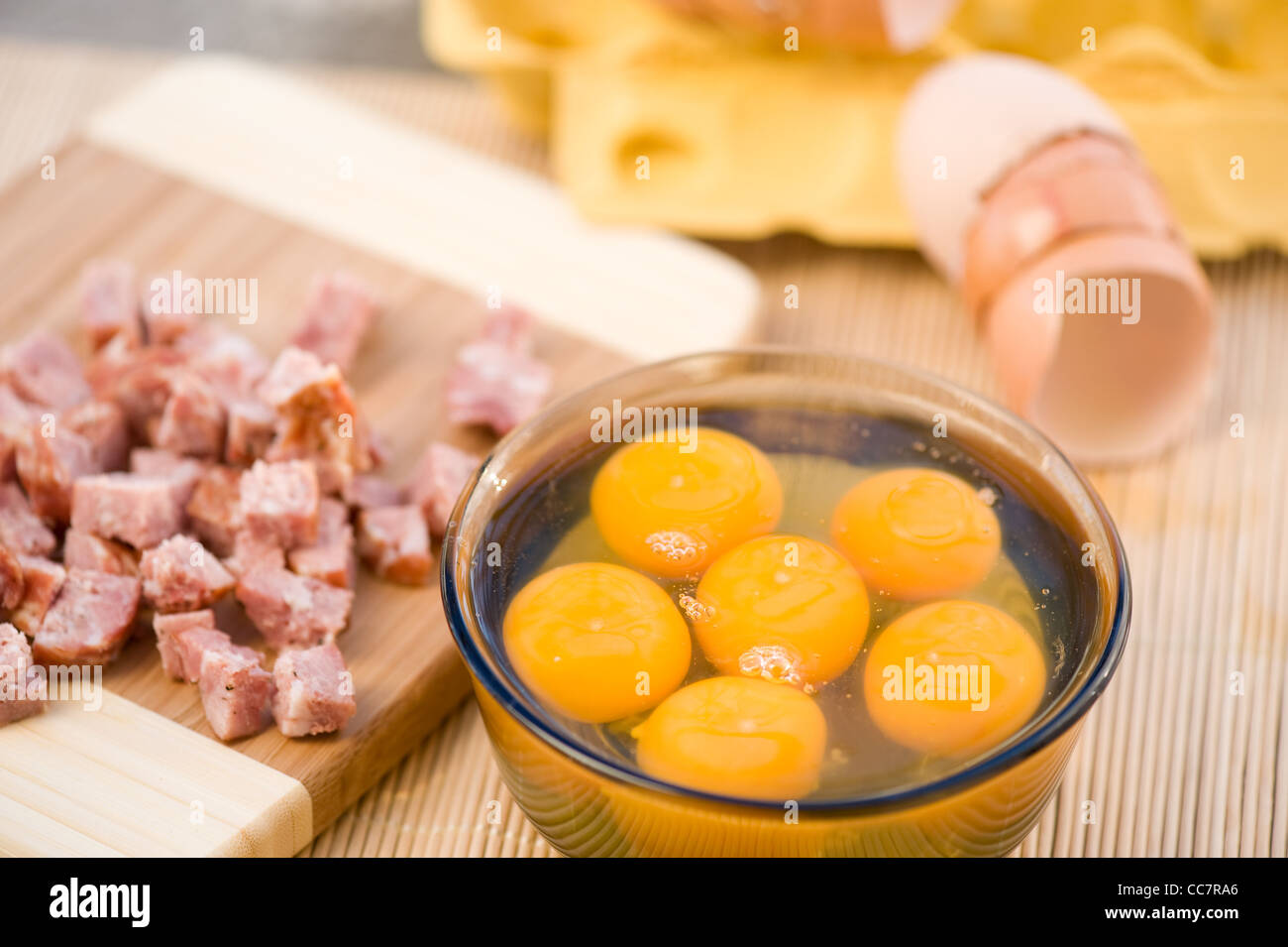 rohes Eigelb im Glas Schale und schneiden Wurst Stockfoto