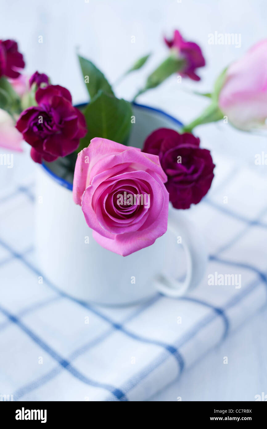 Rosa Rosenstrauß in einer weißer Emaille-Tasse Stockfoto