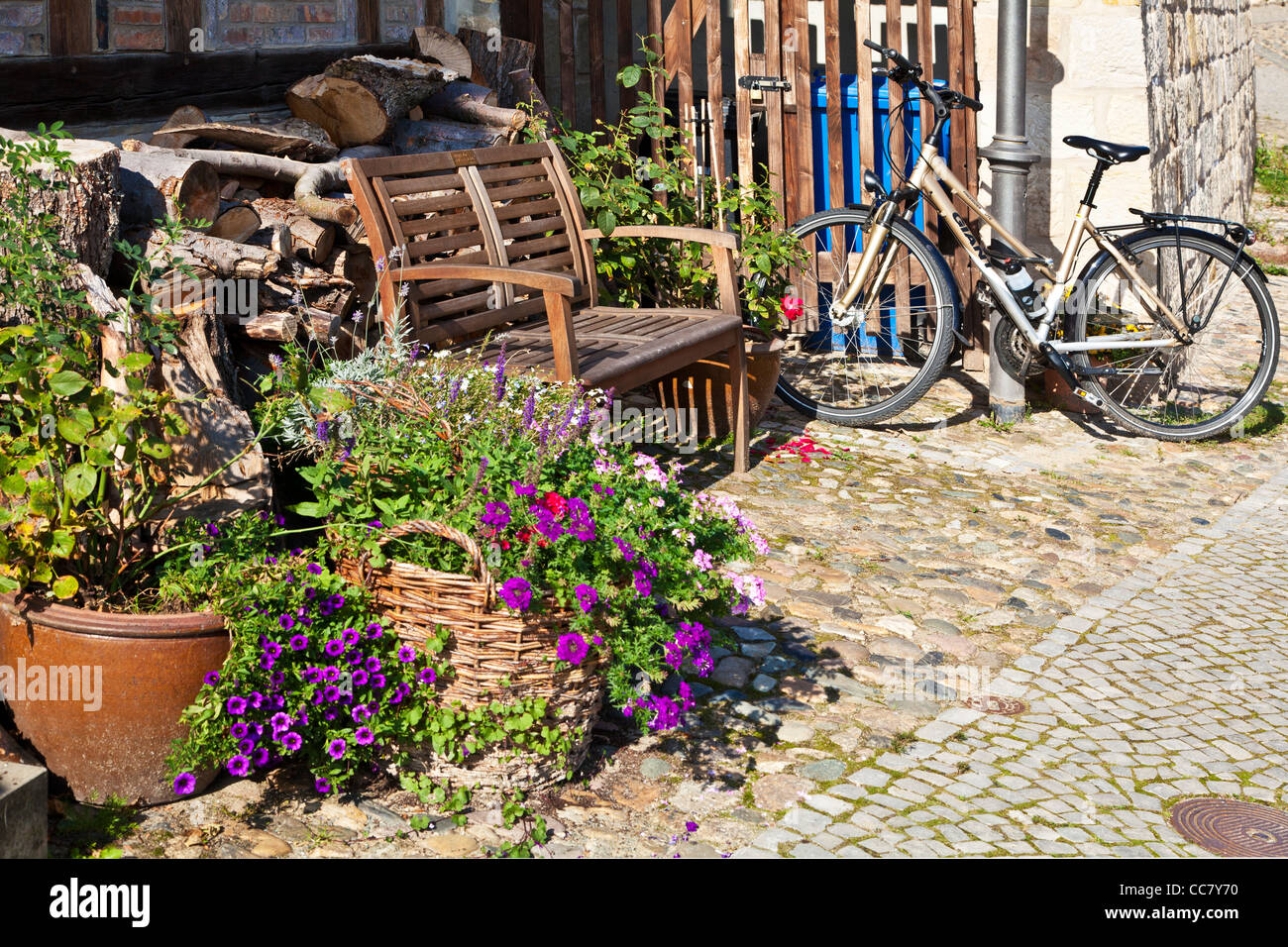 Fahrrad und Holzsitz vor einem Haus in der UNESCO-Welterbe-Stadt Quedlinburg, Deutschland. Stockfoto