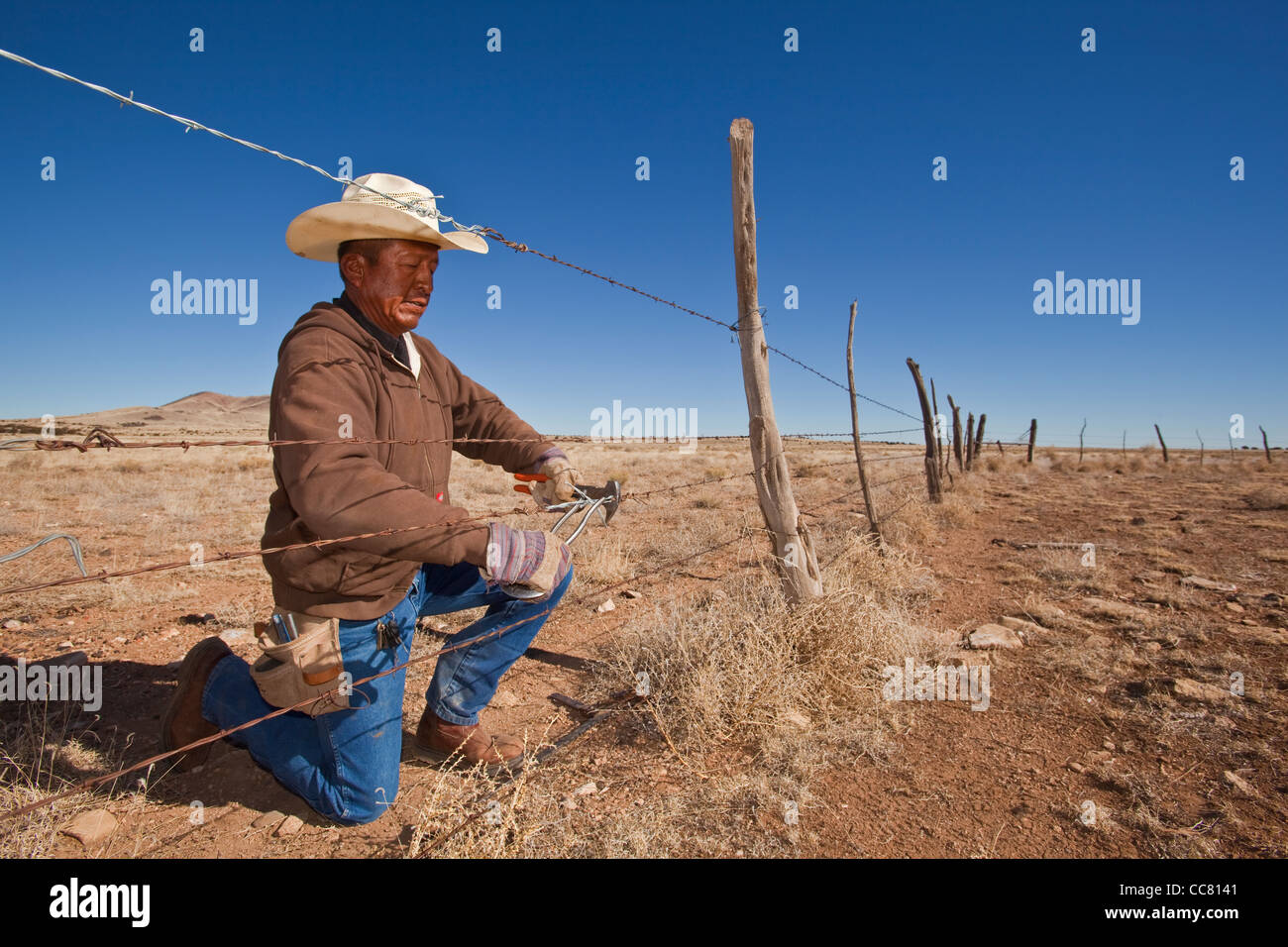 Navajo Zaun Arbeiter, Reparatur von Stacheldraht auf der CO Bar Ranch nördlich von Flagstaff, Arizona, USA Stockfoto