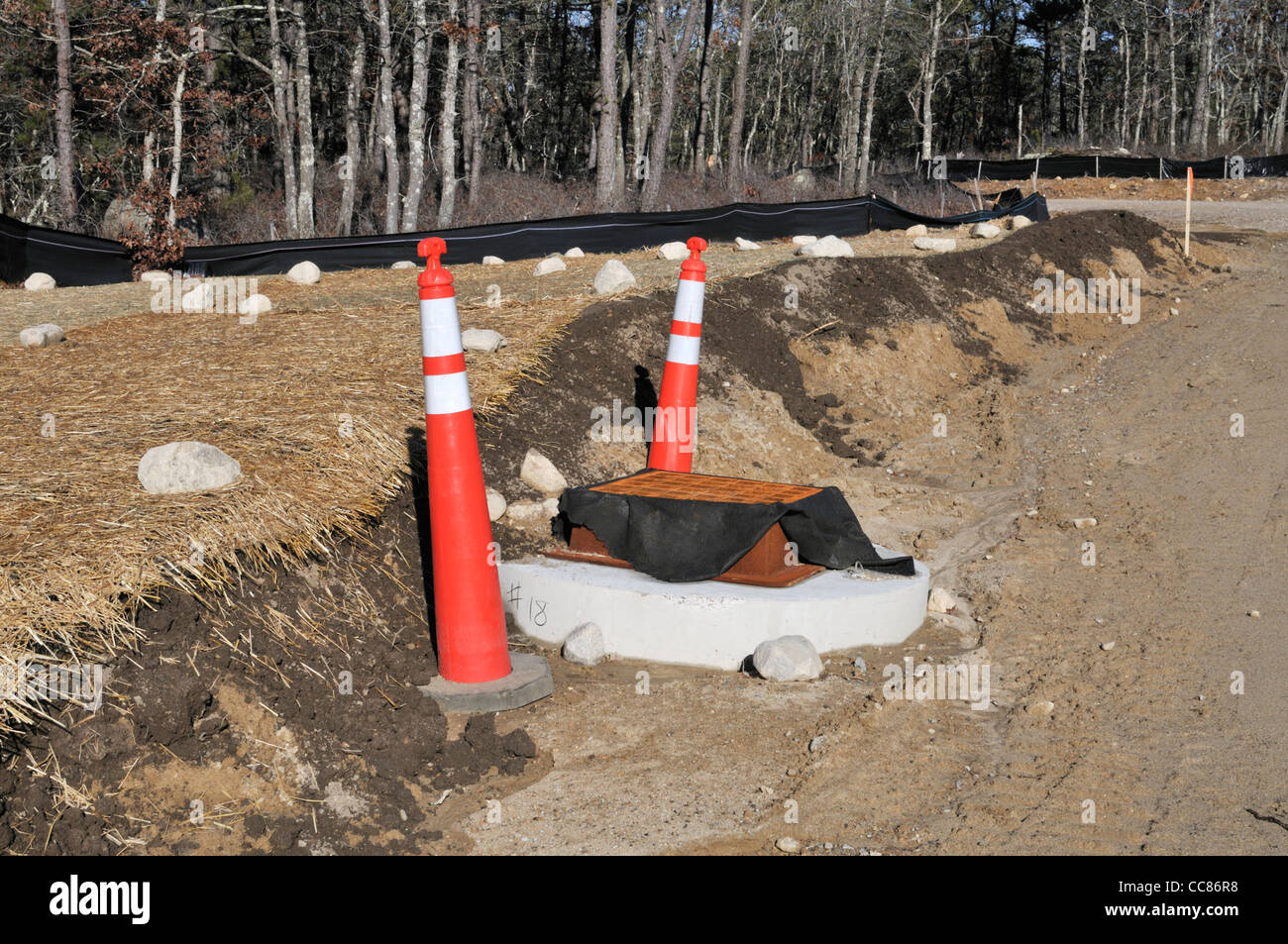 Neue unbefestigte Straße Baustelle mit Sturm abflußabfluß an Stelle Stockfoto