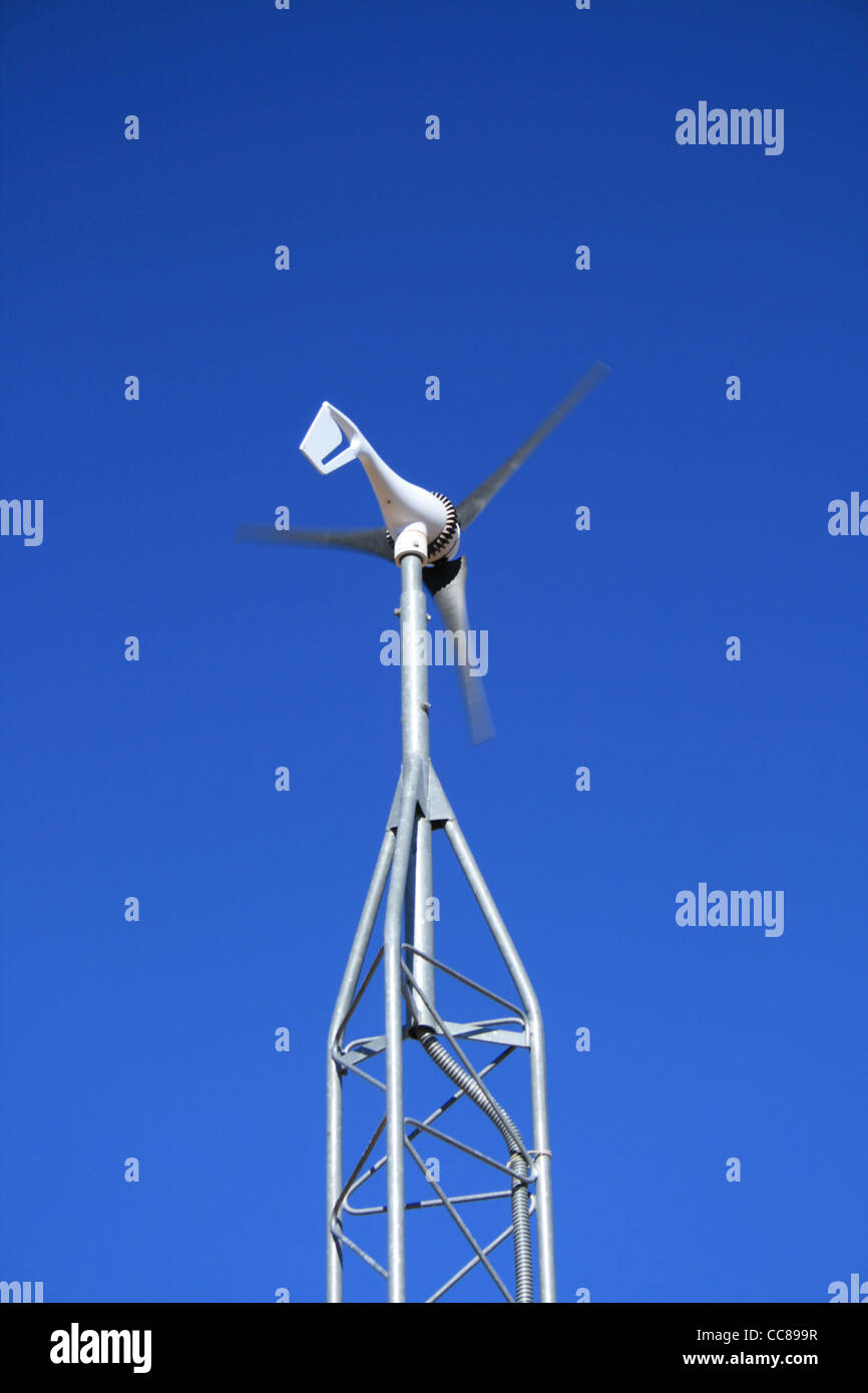 eine kleine elektrische Erzeugung von Windmühle vor blauem Himmel Stockfoto