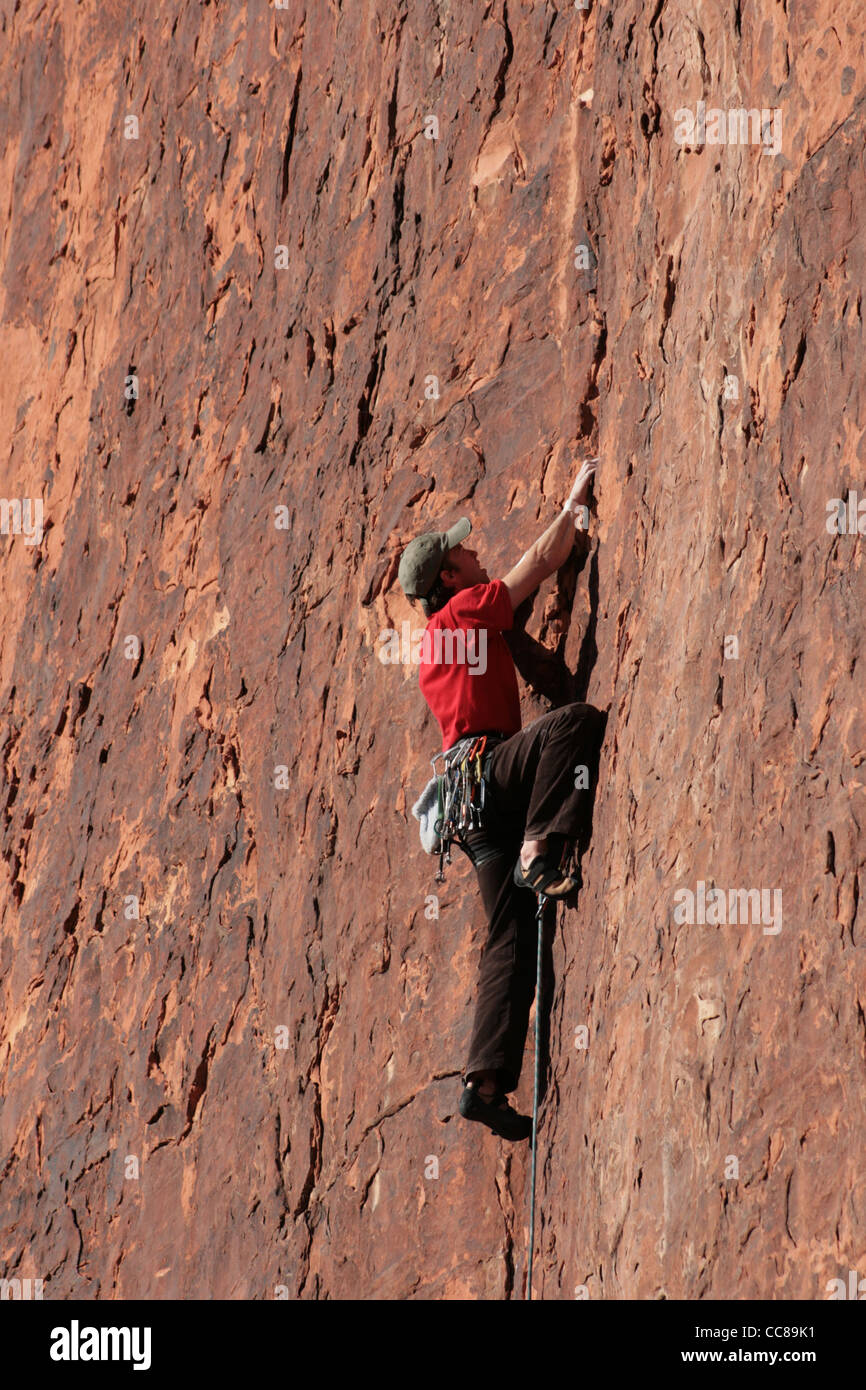 Mann im roten Felsen im Schwierigkeitsklettern bei einer roten Sandstein-Klippe bei Red Rocks, Nevada Stockfoto