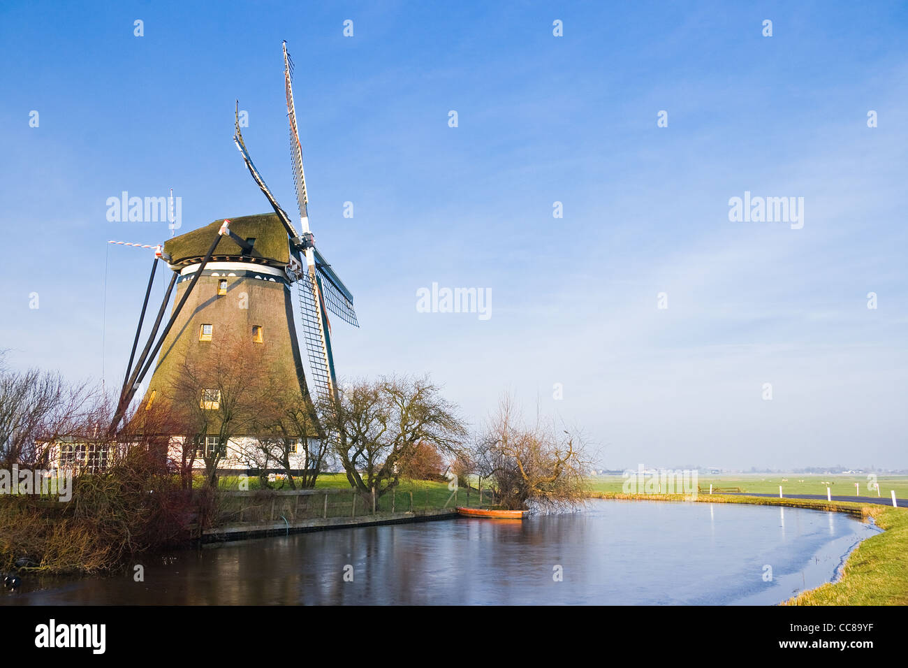 Holländische Polderlandschaft mit Windmühle an eisigen kalten und sonnigen Wintertag Stockfoto