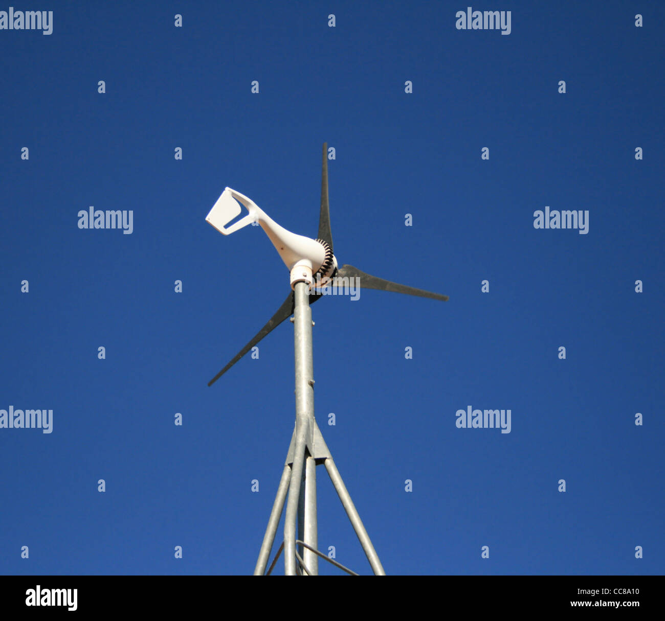 kleine elektrische Erzeugung von Windmühle vor blauem Himmel Stockfoto