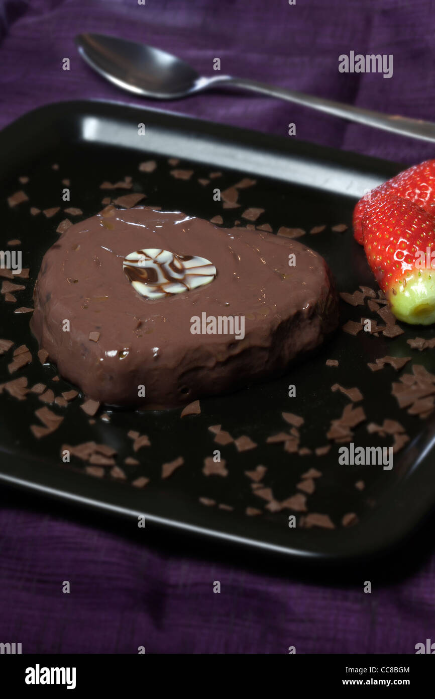 Mousse au Chocolat in Herzform mit Erdbeeren Stockfoto