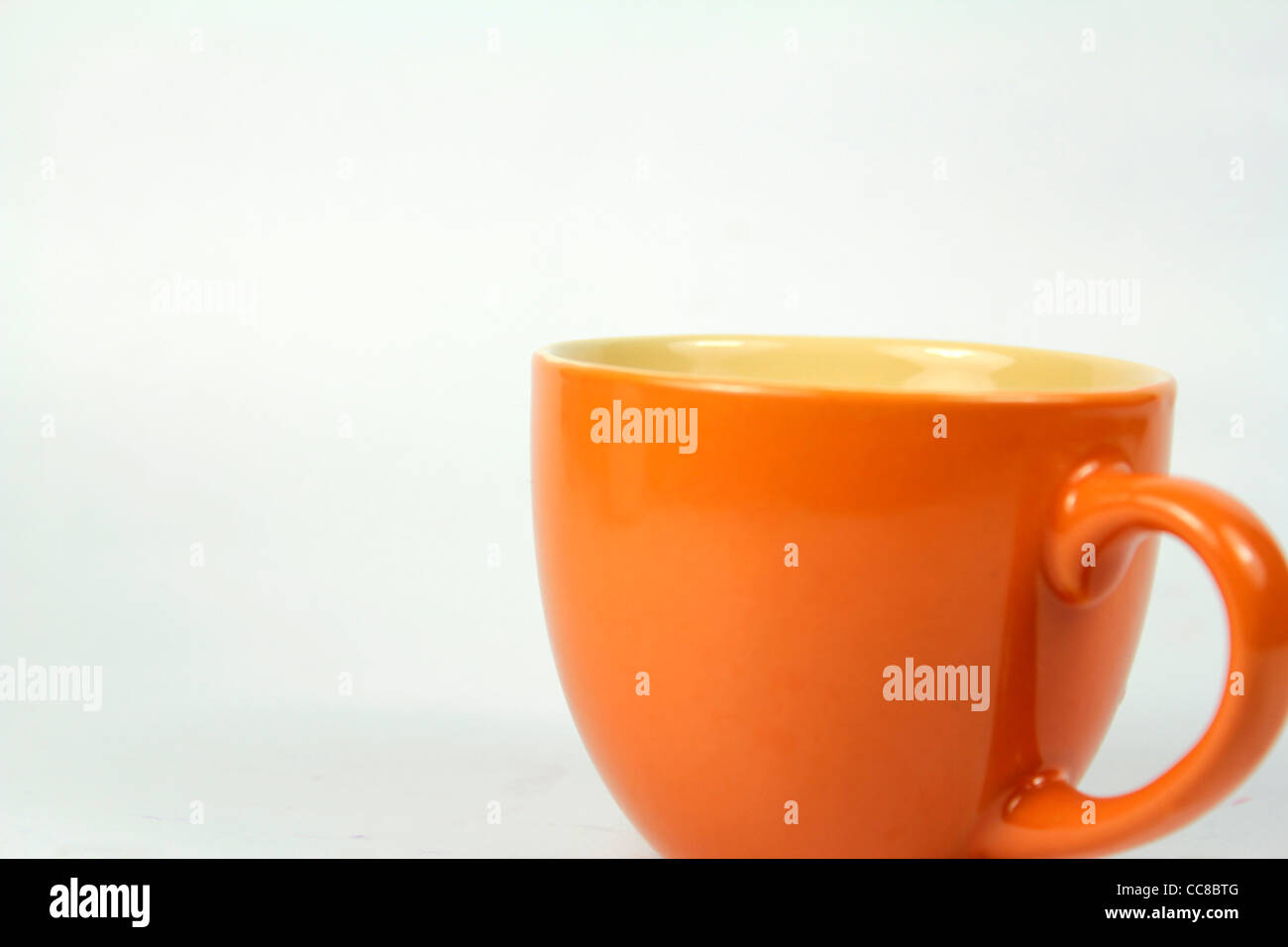 Orange-Cup gegen den weißen Hintergrund Stockfoto