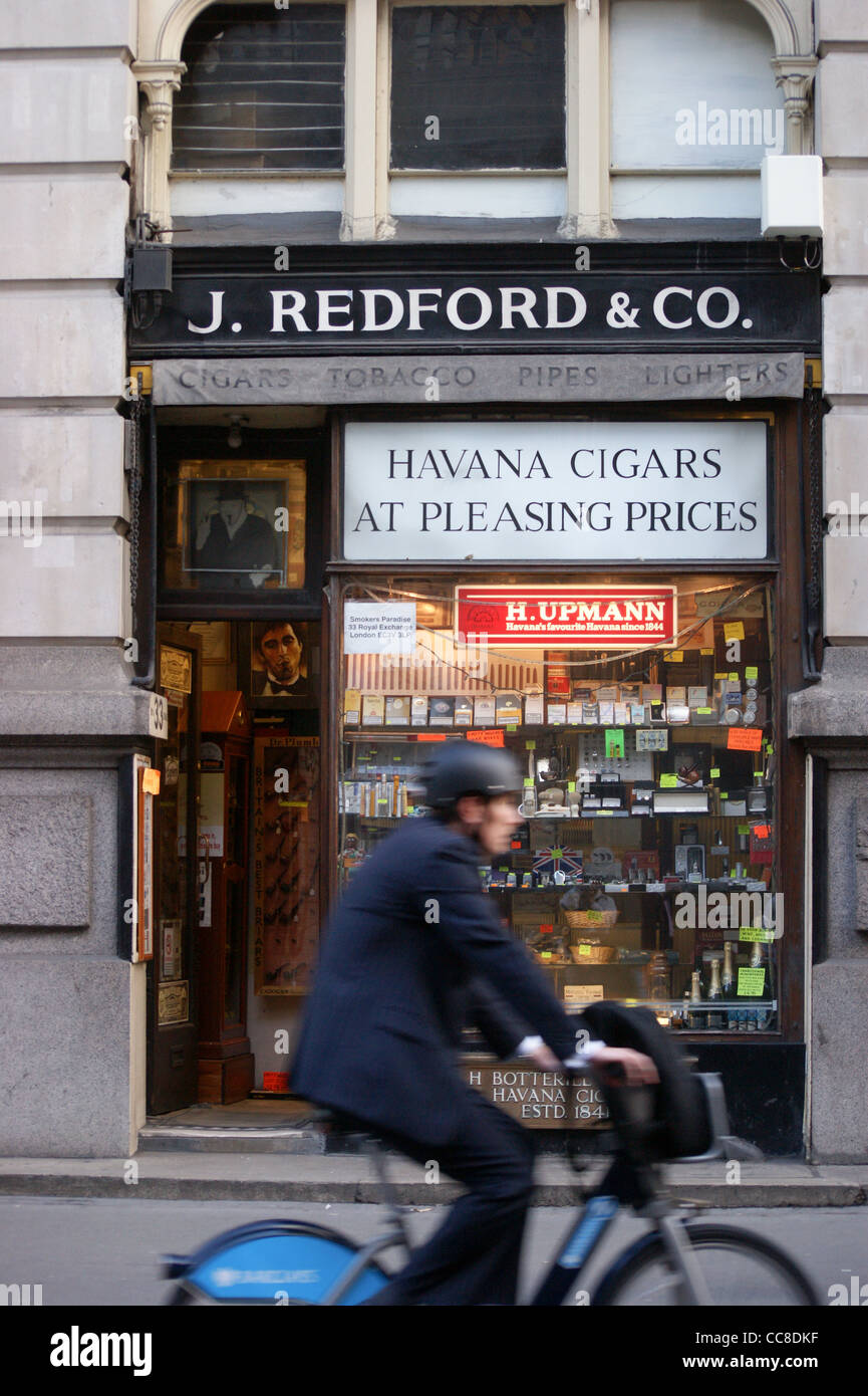 J. Redford & Co. Zigarre kaufen, 33 Royal Exchange, City of London, England mit einem Mann auf einem Boris-Bike vor Stockfoto