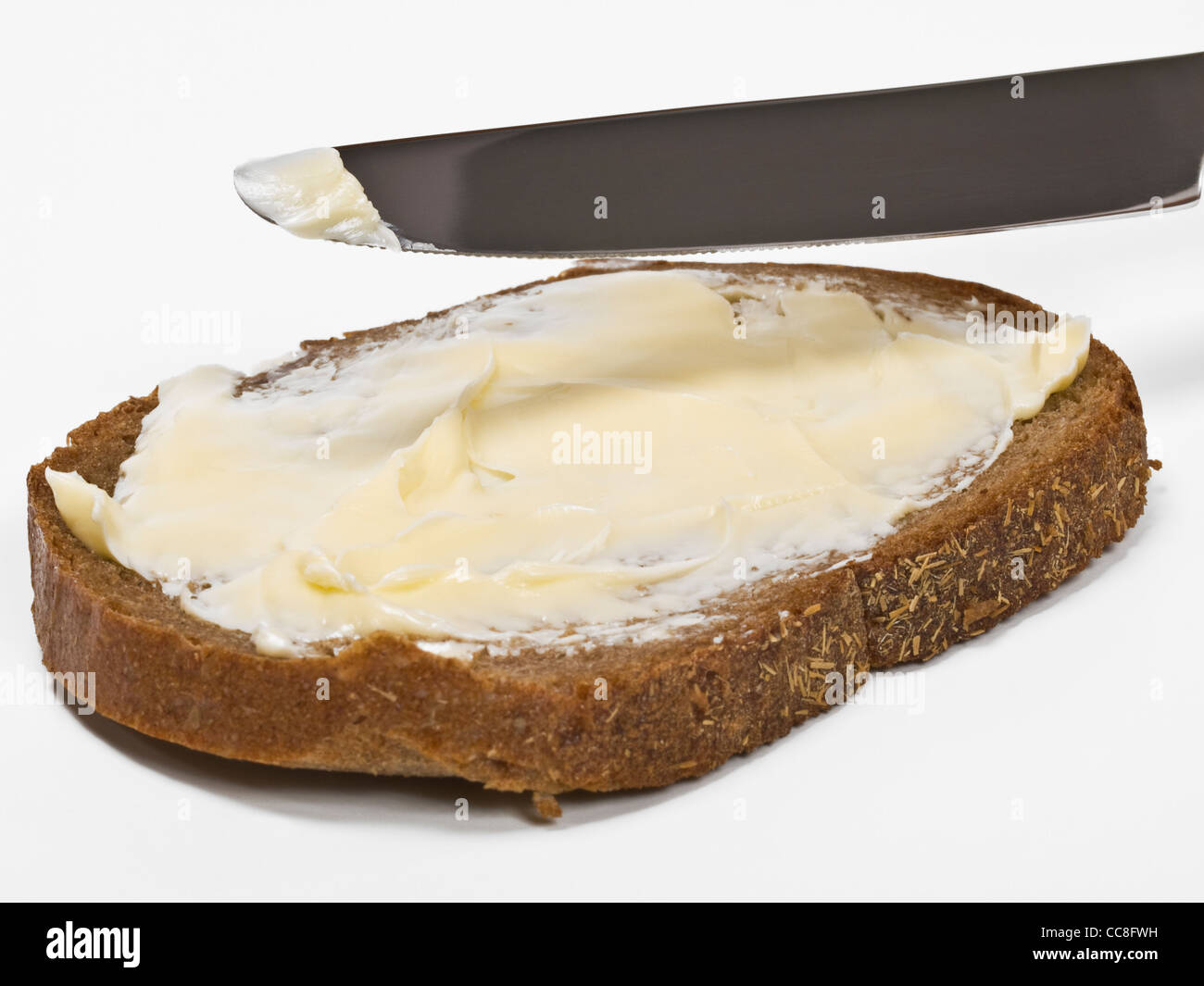 Eine Scheibe Schwarzbrot Wird Mit Butter Bestrichen | um eine Scheibe Schwarzbrot butter Stockfoto