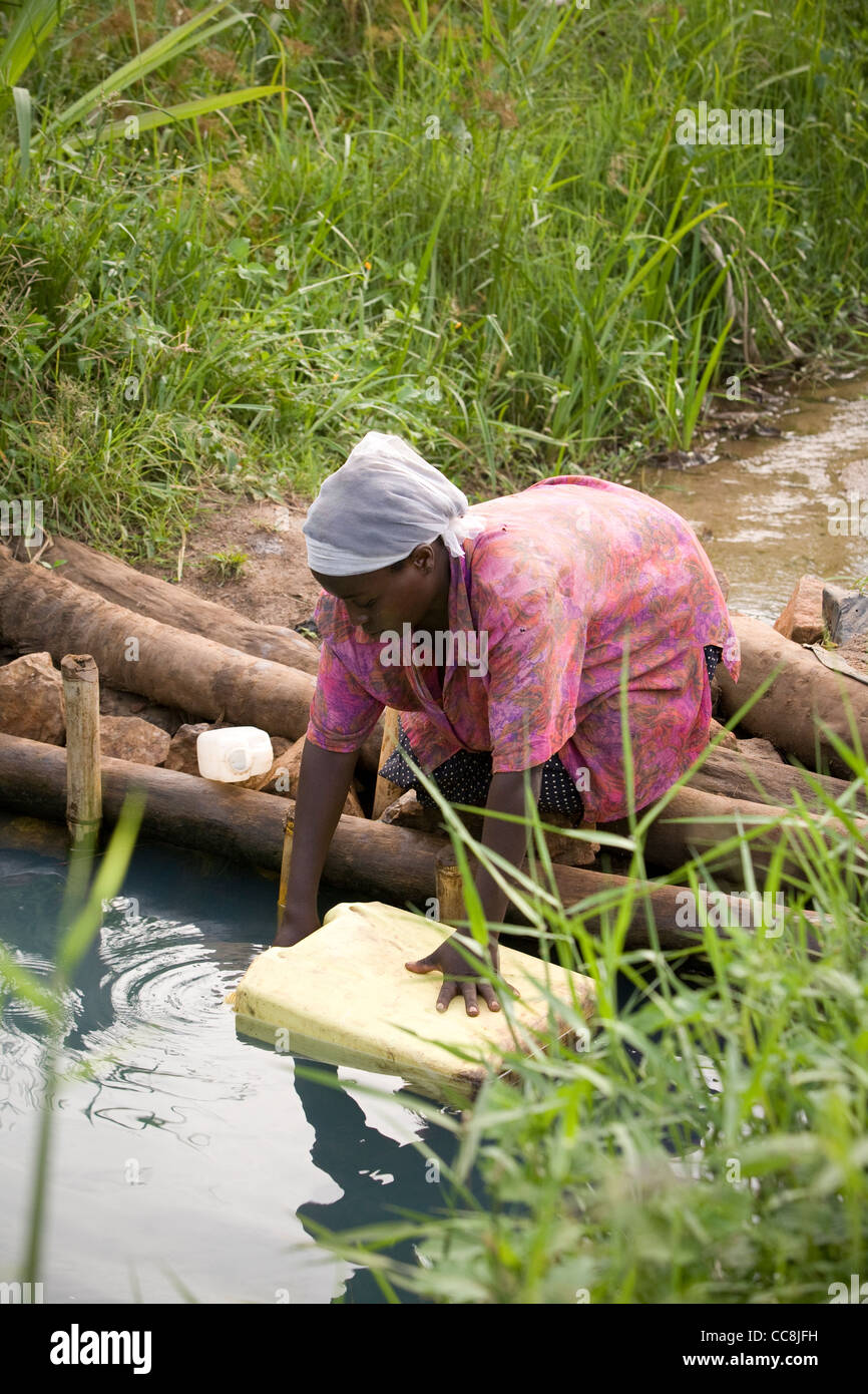 Eine Frau holt Wasser in ländlichen Masaka District, Uganda, Ostafrika. Stockfoto