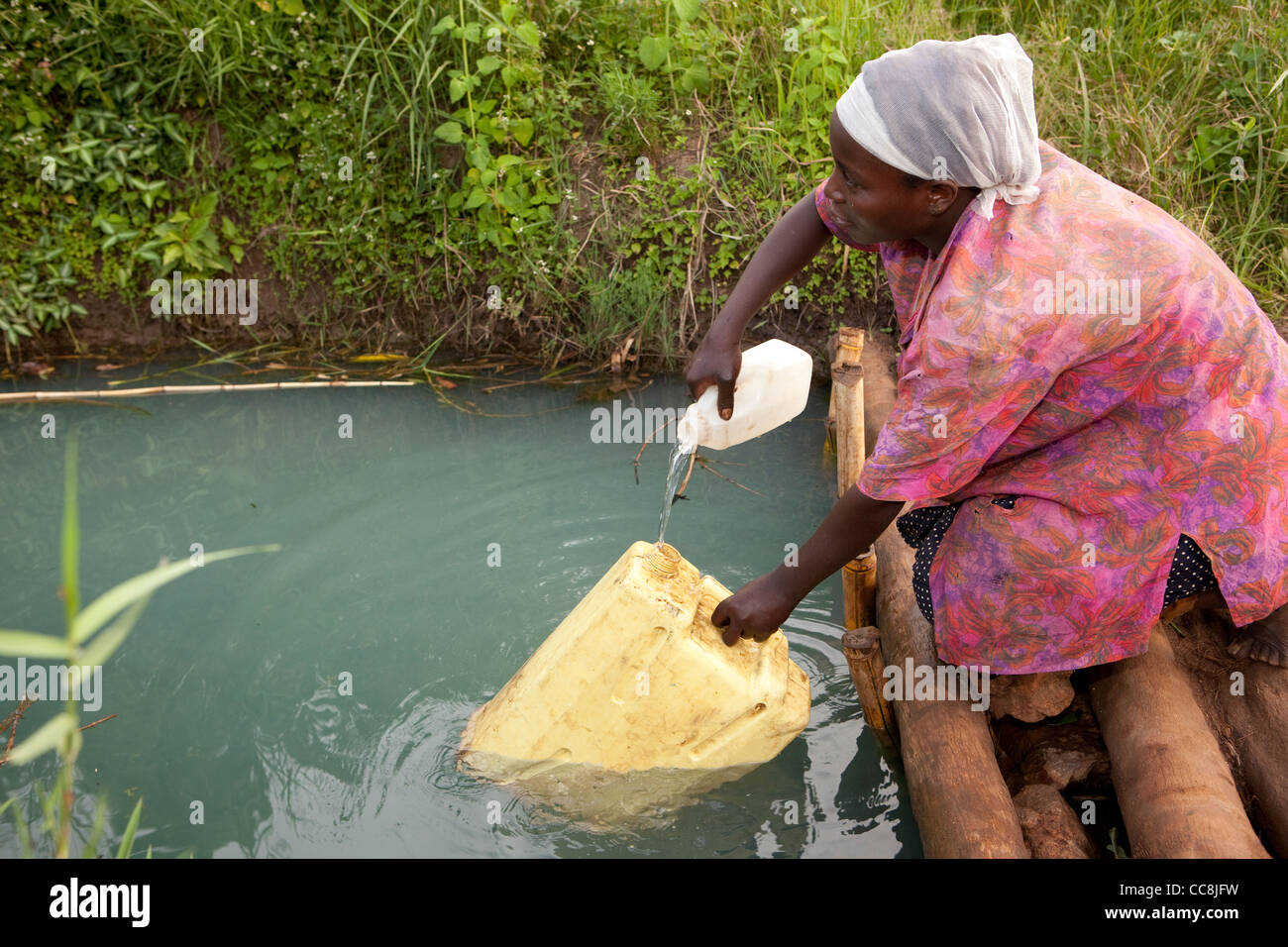 Eine Frau holt Wasser in ländlichen Masaka District, Uganda, Ostafrika. Stockfoto