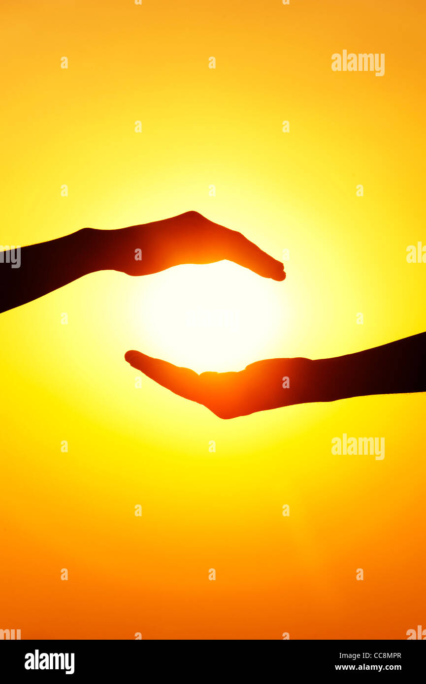 Indischer Mann und Inderin Hände halten die Sonne. Silhouette. Indien Stockfoto