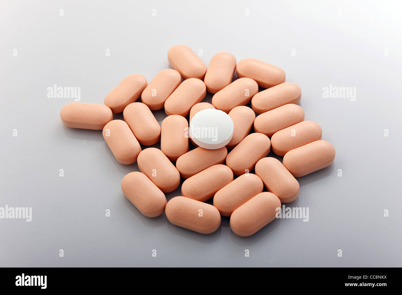 Eine Handvoll rose Pillen auf grauem Hintergrund Stockfoto