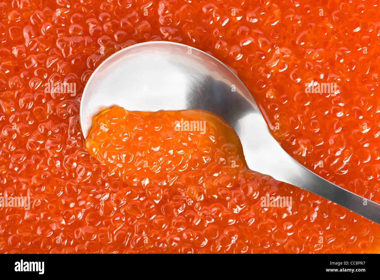 Löffel aus Edelstahl in rotem Kaviar Stockfoto
