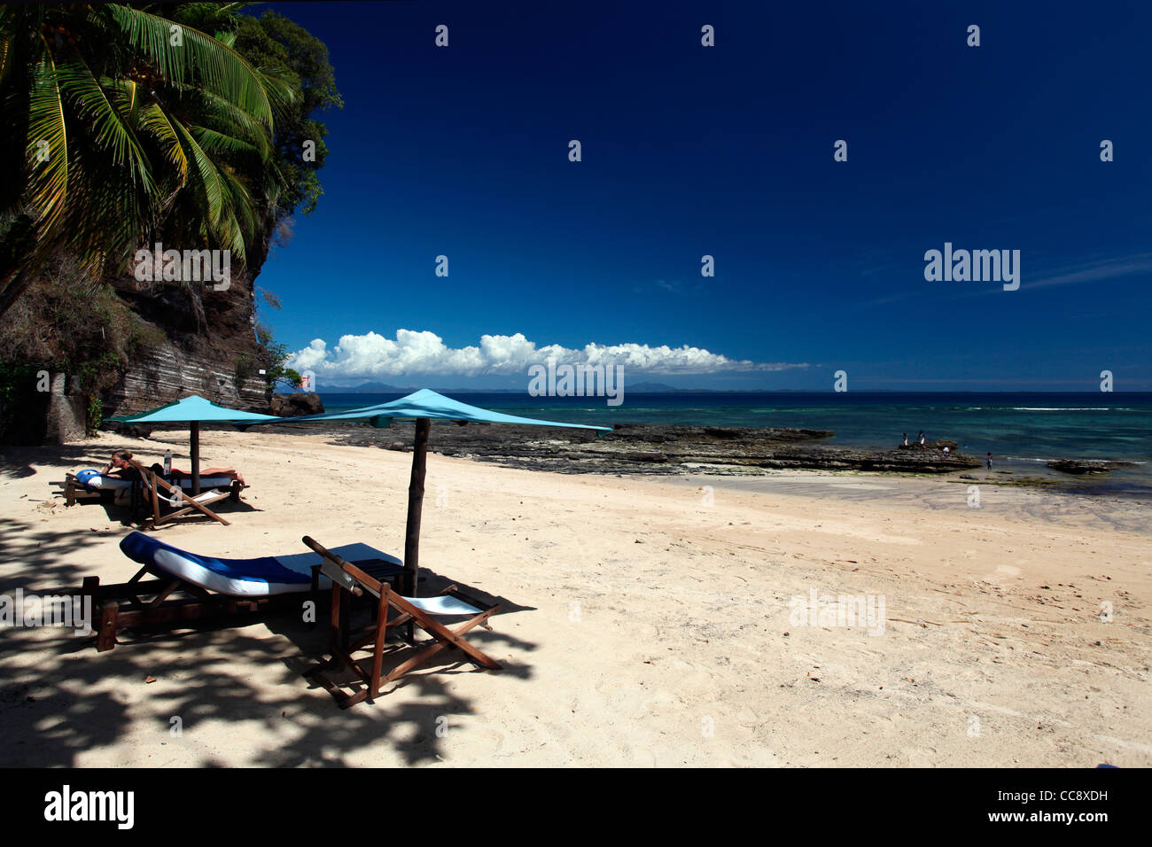Eine kaukasische Frau, die sich am Strand von Ambatoloaka, Ampangorinana, Nosy Be, Nordwesten Madagaskars, Afrika sonnt Stockfoto