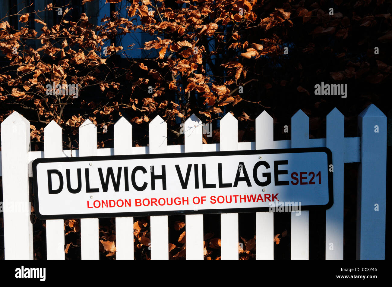 Straßenschild auf einem weißen Holzzaun für Dulwich Dorf, London Borough of Southwark, SE21 Stockfoto