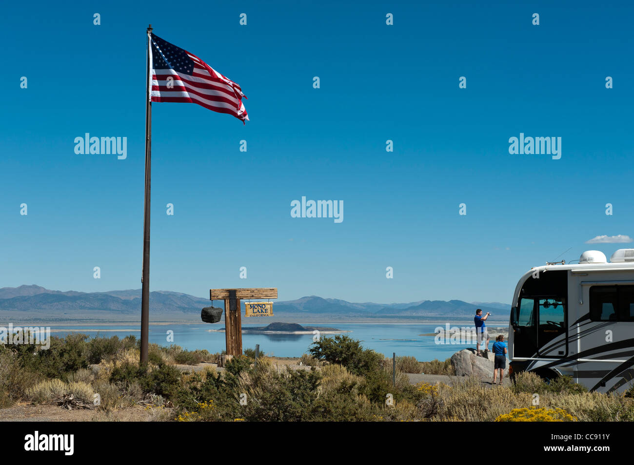 Touristen neben einem Winnebago und die amerikanische Flagge, Mono Lake, Tioga Gas und Geschenk Mart Kalifornien. USA Stockfoto