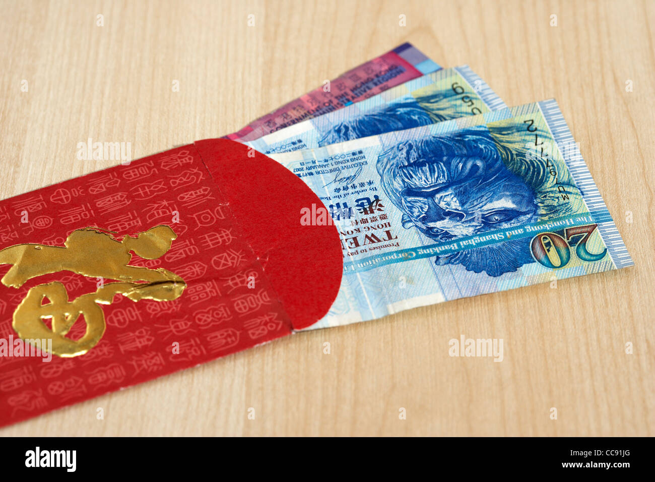 Hongkong-Dollar Bargeld Währung in einem rot-goldenen Geschenk Umschlag traditionell in China an Silvester oder Hochzeiten gegeben Stockfoto