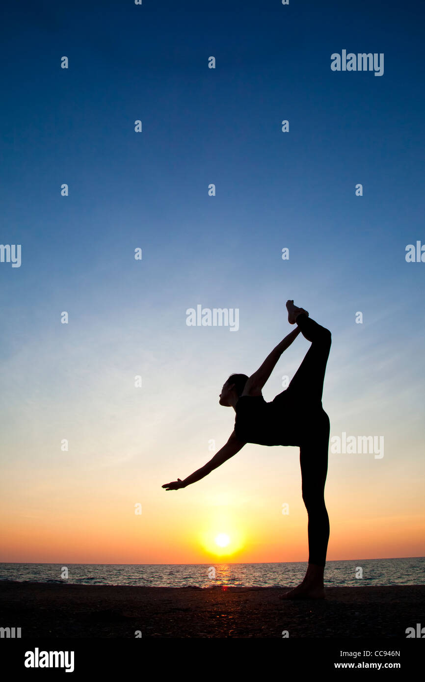 Silhouette der Tänzer in den frühen Morgenstunden am Seeufer Stockfoto