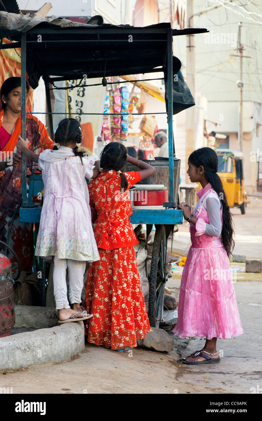 Junge indische Mädchen kaufen Dosa zum Frühstück aus einem Warenkorb in einem indischen Straße. Puttaparthi, Andhra Pradesh, Indien Stockfoto