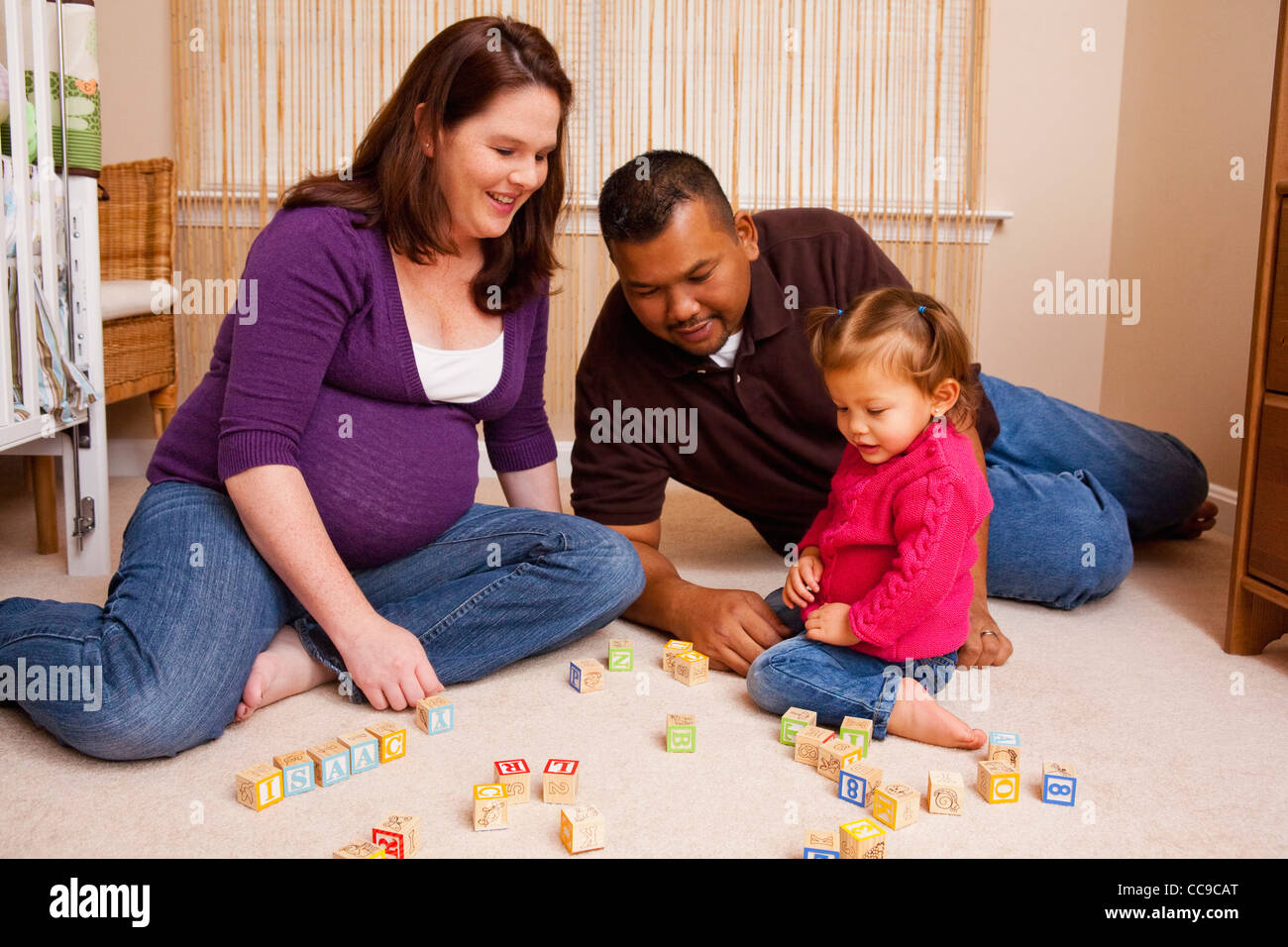 Familie sitzt am Boden spielen mit Bausteinen Stockfoto