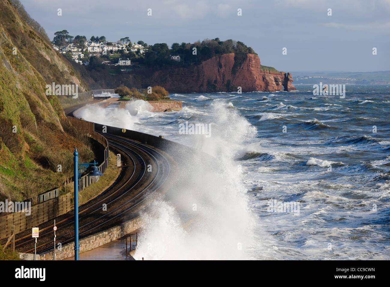 Wellen brechen über die Bahnlinie Teignmouth South Devon UK Stockfoto