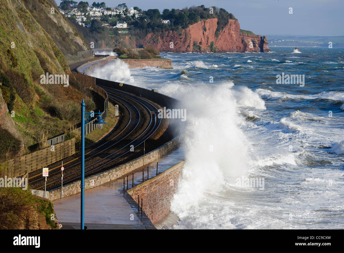 Wellen brechen über die Bahnlinie Teignmouth South Devon UK Stockfoto