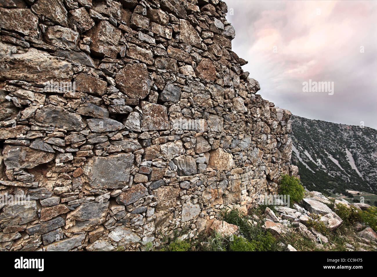 Alte Steinmauer Ruinen gegen einen dramatischen Wolkenhimmel. Provinz Lassithi, Kreta, Griechenland. Stockfoto