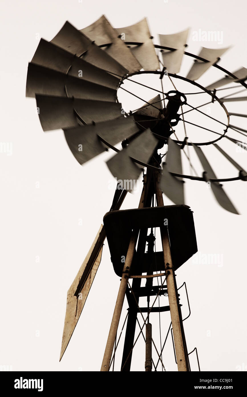 Alte klassische amerikanische Windmühle Nahaufnahme. Propeller in Bewegung. Vertikale Zusammensetzung. Sepia - Stil Foto. Stockfoto