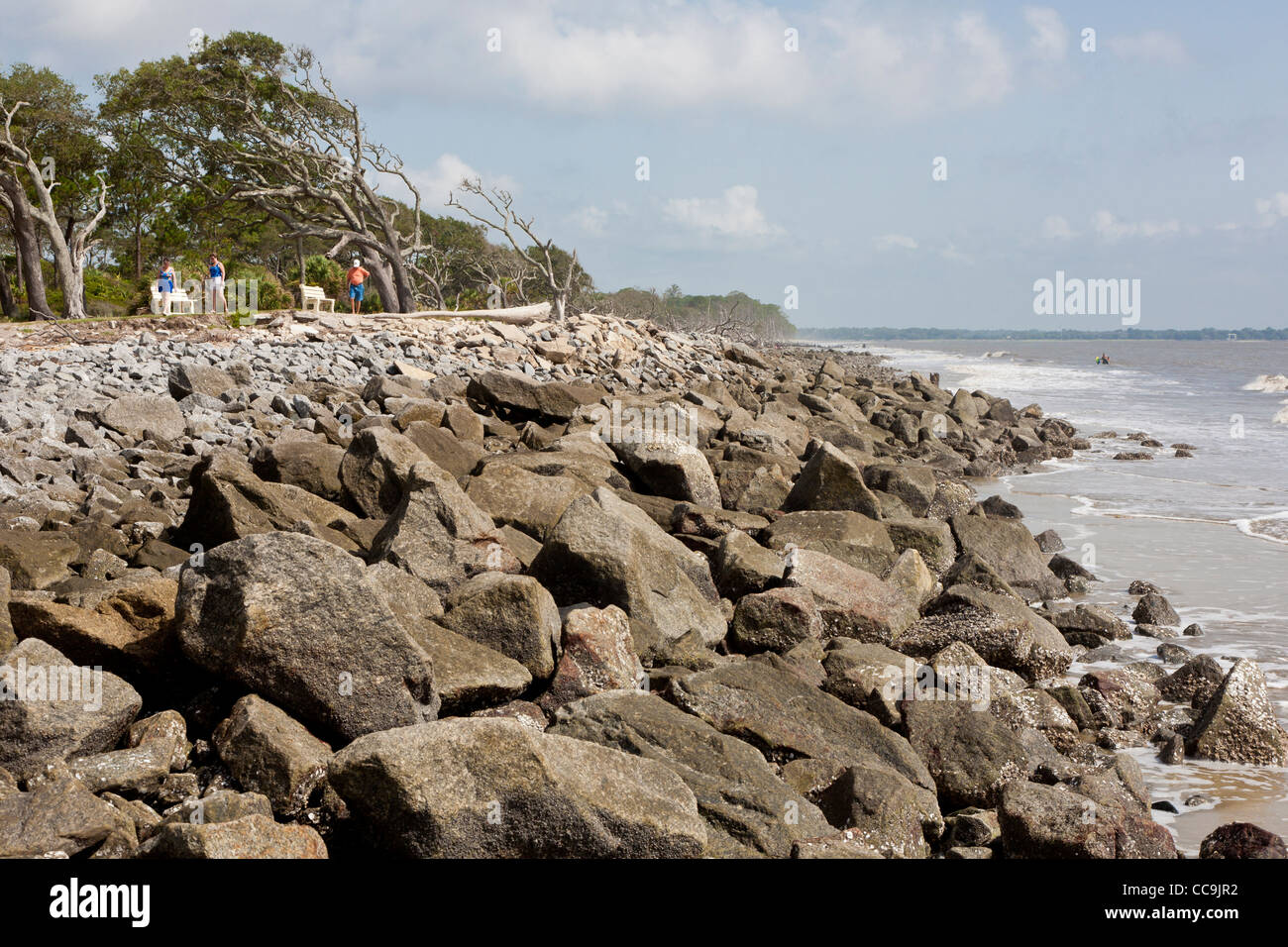 Touristen Fuß entlang der felsigen Küste von Jekyll Island, Georgia. Stockfoto