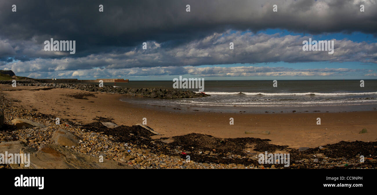 Panoramablick auf Skinningrove Steg und Strand unter Gewitterhimmel Stockfoto