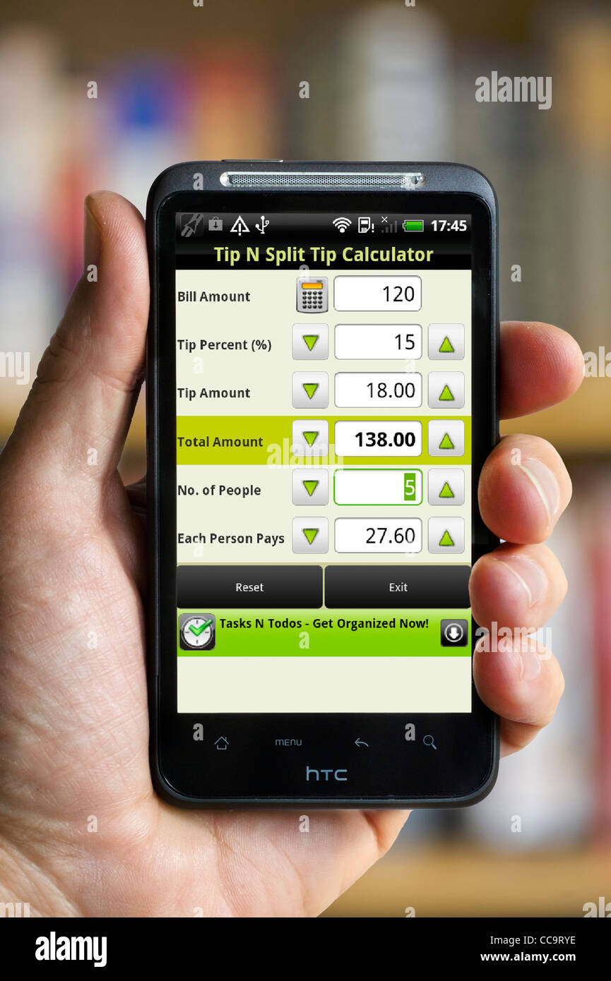 Mithilfe einer Tip Calculator app auf einem android HTC-smartphone Stockfoto
