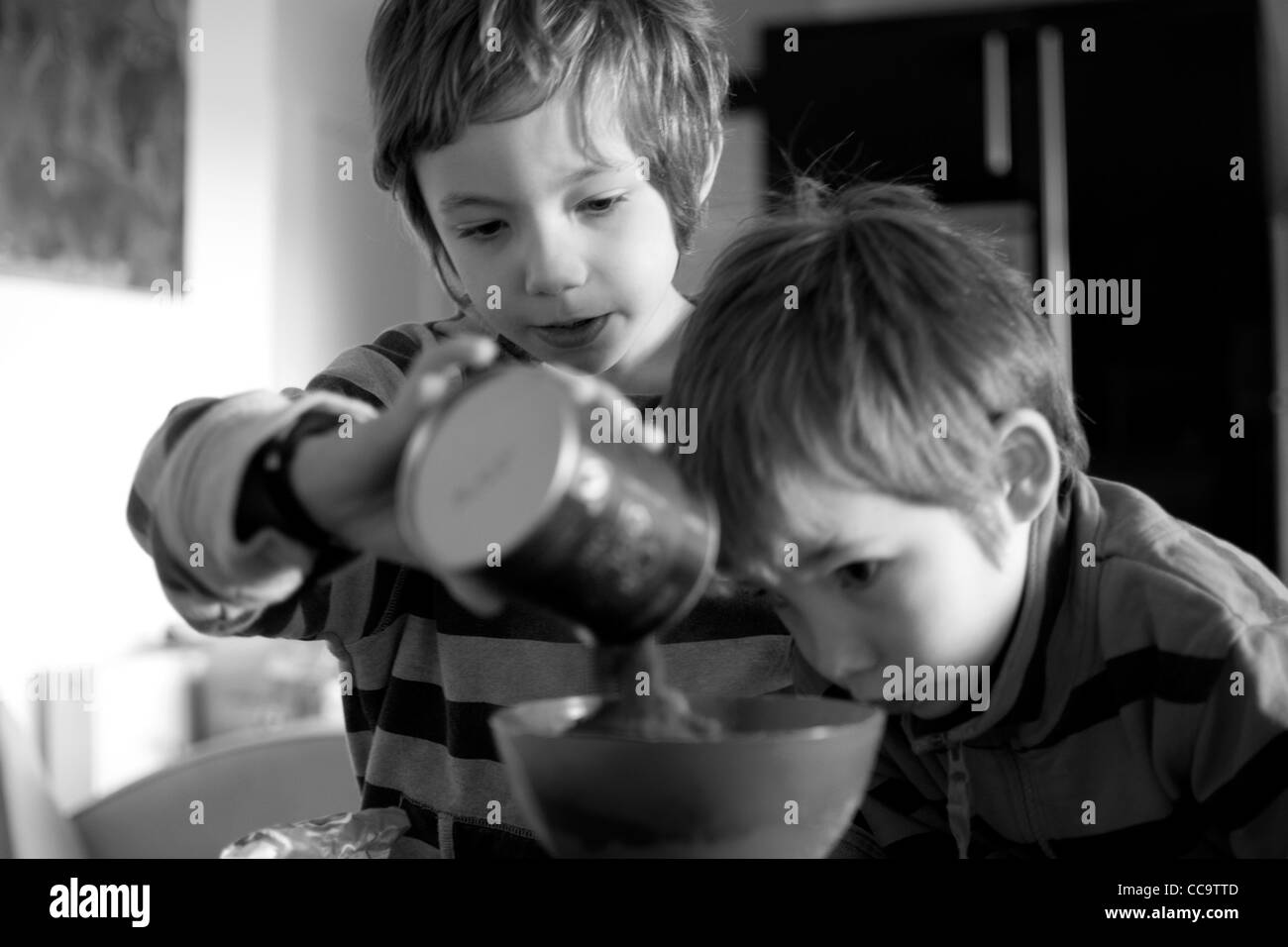 zwei Kinder gemeinsam einen Schokoladenkuchen Backen Stockfoto
