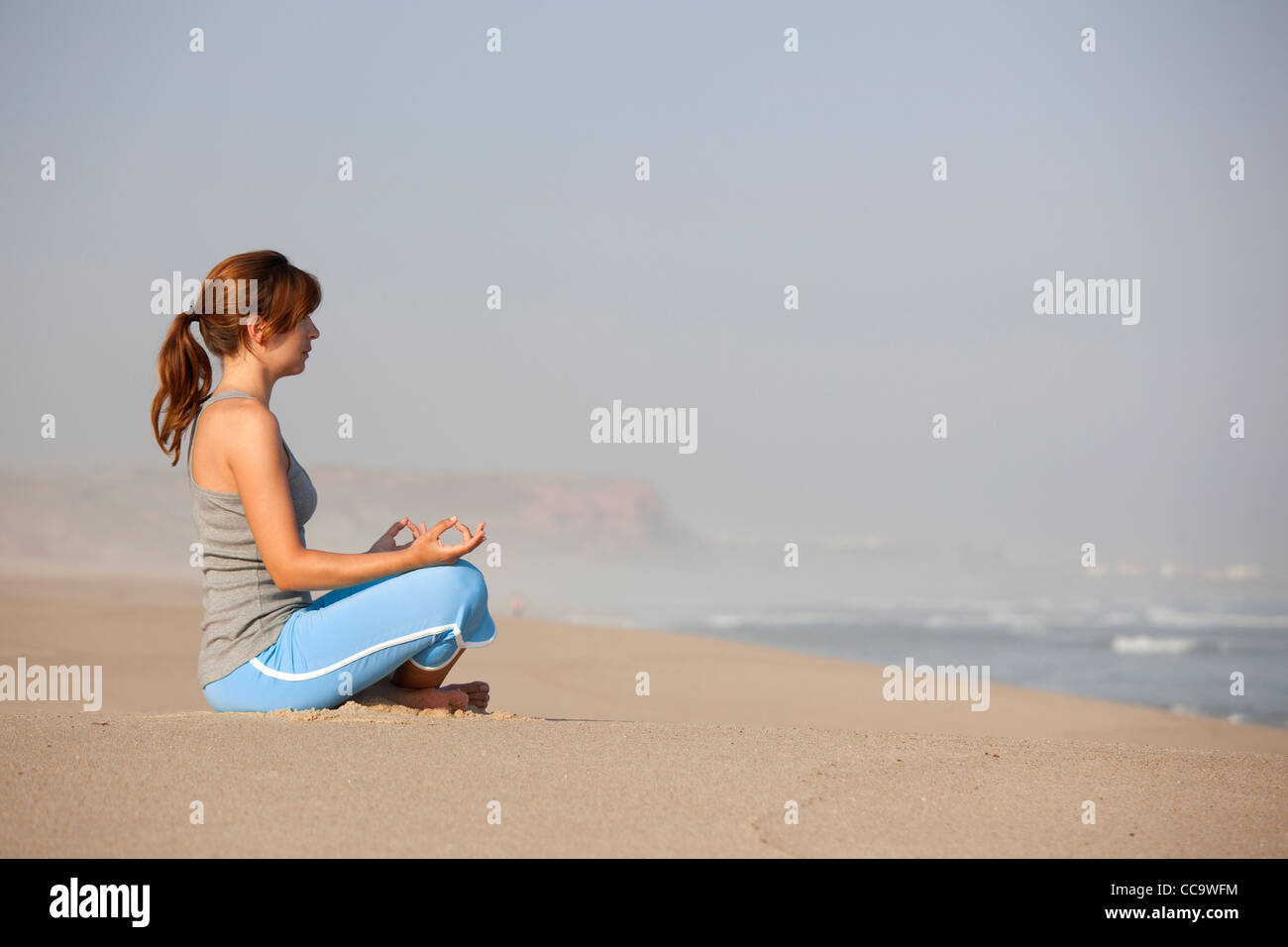 Schöne junge Frau am Strand Yoga Übungen Stockfoto