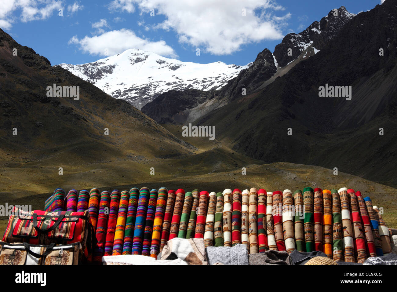 Textilstand am La Raya Pass neben der Bahn von Puno nach Cusco (verwendet von Orient Express-Zügen), im Hintergrund Mt Chimboya, Peru Stockfoto