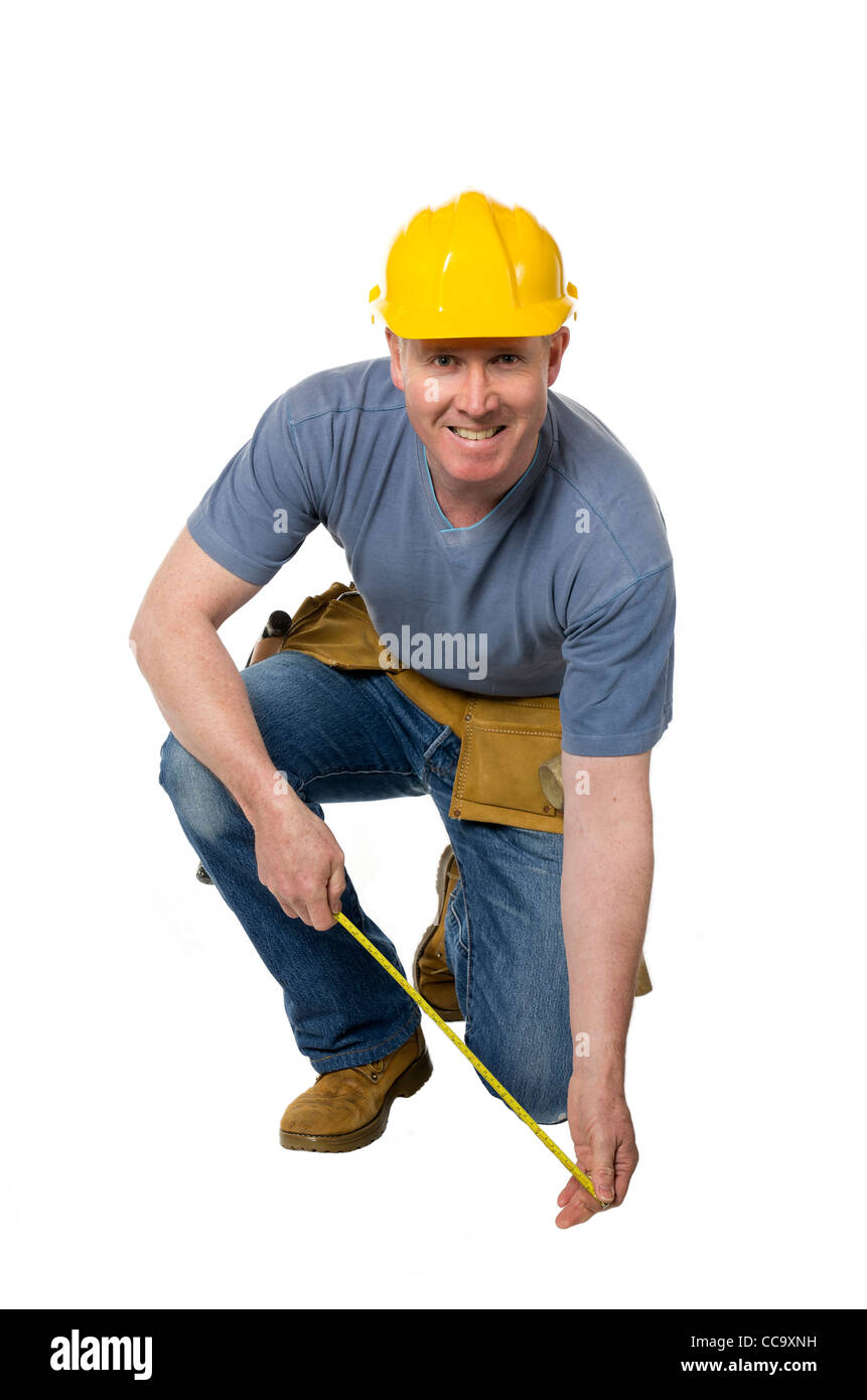 Bauarbeiter auf weißem Hintergrund kniet und misst Stockfoto