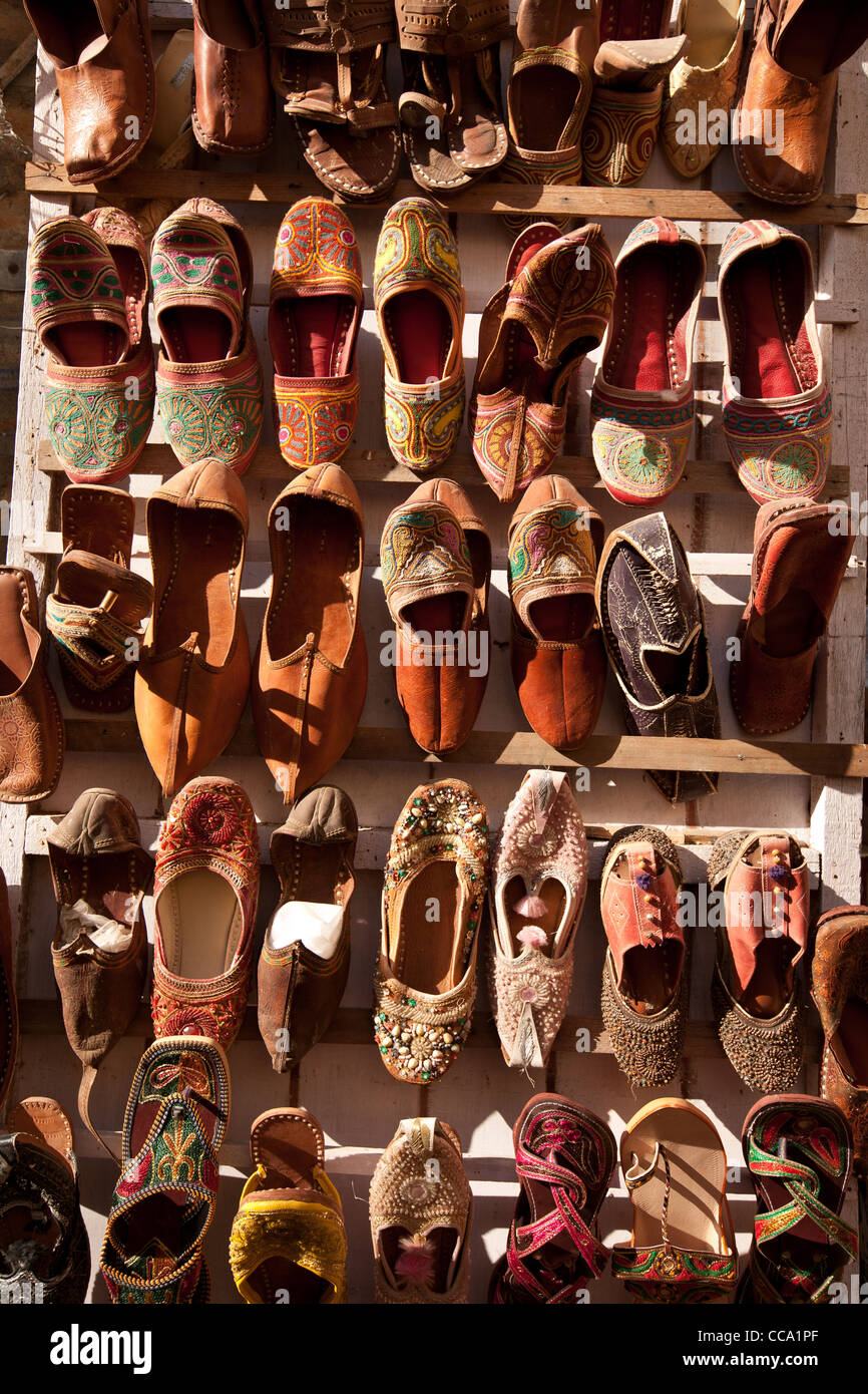 Leder-Schuhe und Hausschuhe zum Verkauf als Andenken an eine Wand in Jaisalmer Fort, in Rajasthan, Indien. Stockfoto