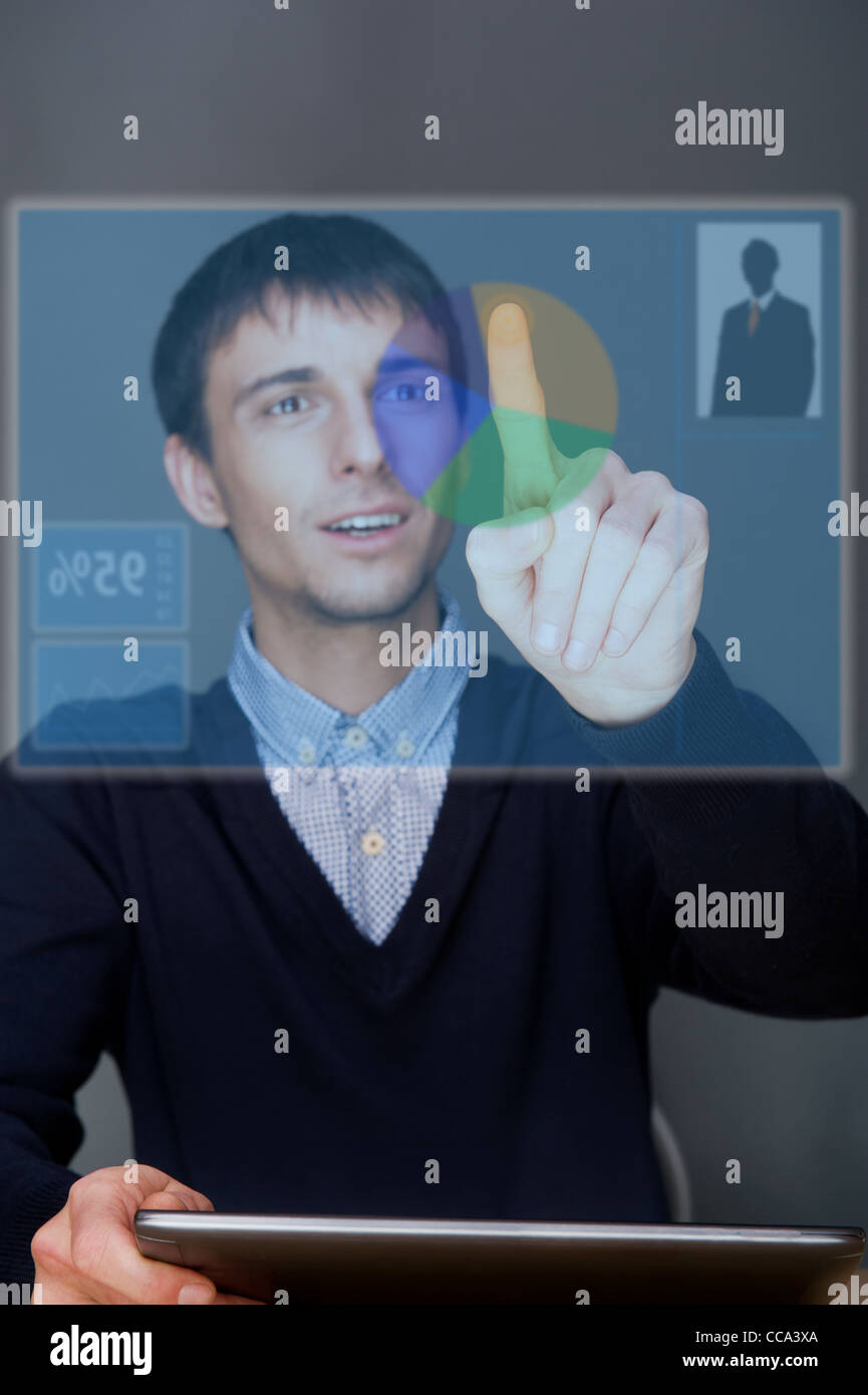 Porträt von Erwachsenen Geschäftsmann auf Knopfdruck Touchscreen beim Sitzen in seinem Büro und arbeitet mit seinem Hightech-computer Stockfoto