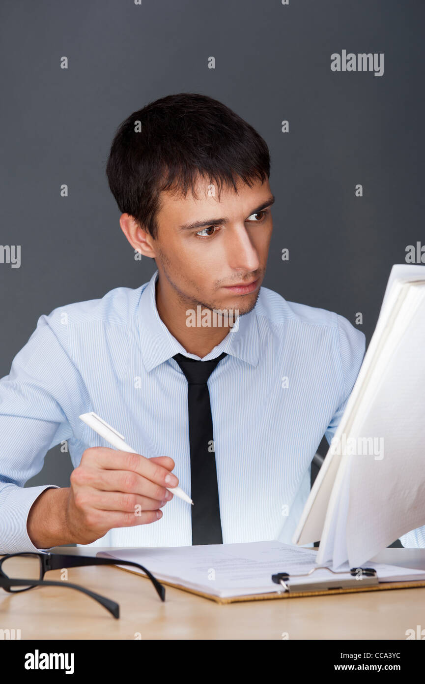 Porträt von einem Erwachsenen Geschäftsmann im Büro zu sitzen und Signieren von Dokumenten Stockfoto