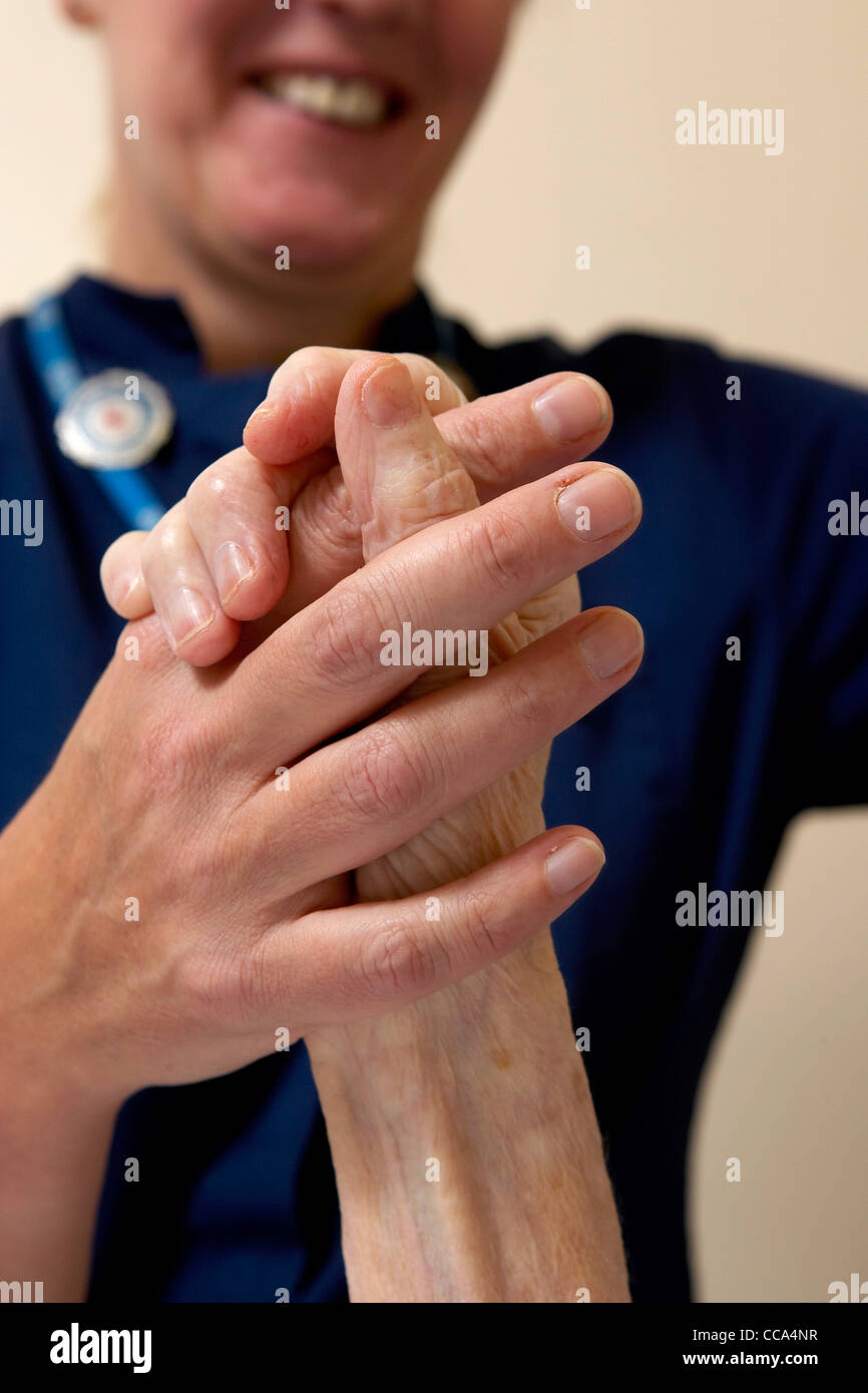Eine A&E Krankenschwester hält die Hand eines ihrer Patienten in einem Krankenhaus in UK. Stockfoto