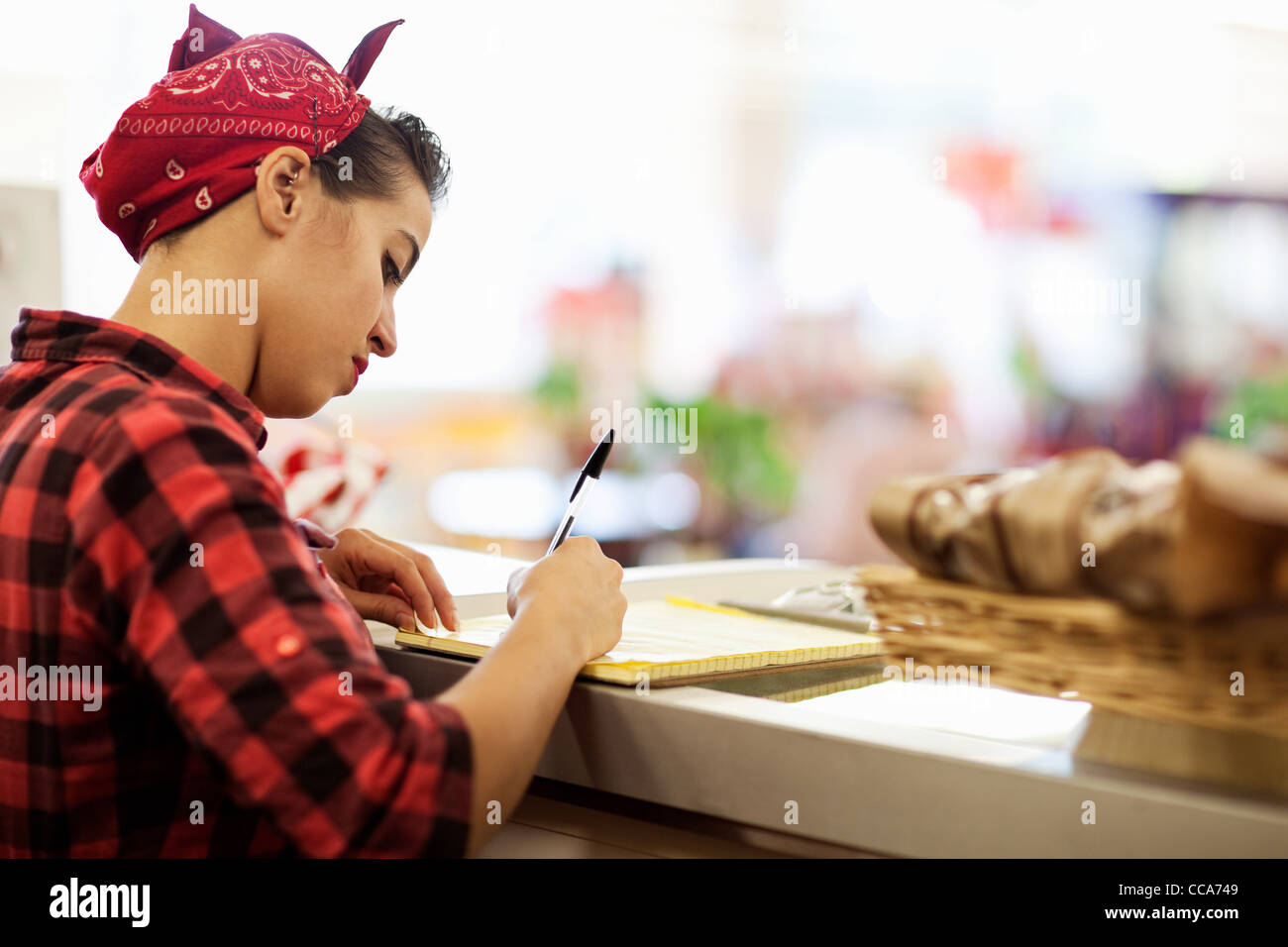 Junge Frau am Schalter der Bäckerei Stockfoto