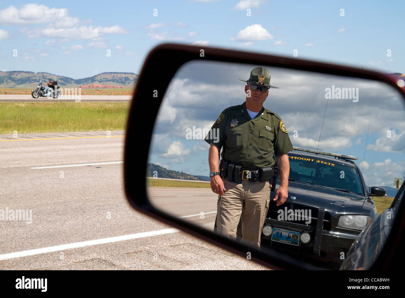 Wyoming Highway Patrol Officer zu sehen im Rückspiegel entlang i-90 in der Nähe der Grenze zu Wyoming, South Dakota, USA. HERR Stockfoto