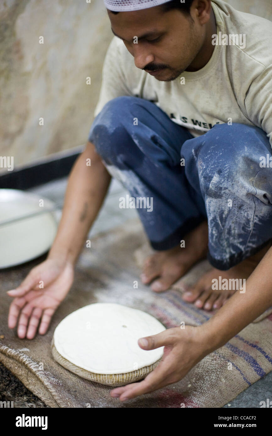 L M Rahman Vorbereitung und Kochen frisches Naan Brot im Tandoor-Ofen Karims Restaurant, Delhi, Indien Stockfoto